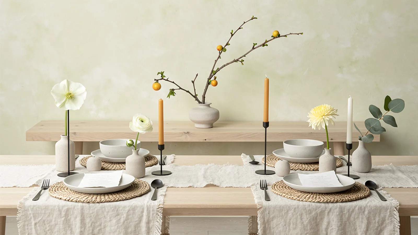 Scandi-Japandi Calm wedding aesthetic — A low oak bench against a lime-washed cream wall, single ikebana branch arrangement, soft overcast light.